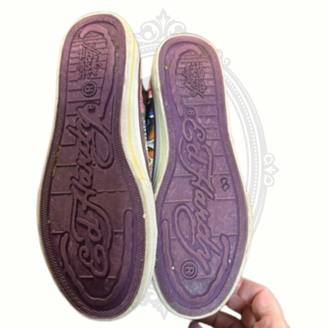 Bottom view of Ed Hardy sneakers showing purple rubber soles with logo and tread wear
