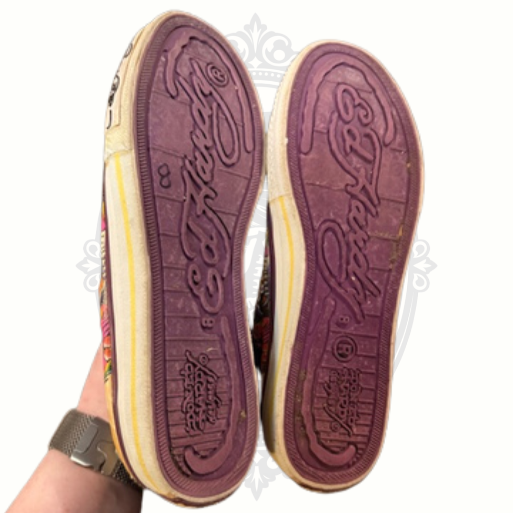 Ed Hardy sneakers held in hand showing purple rubber soles and logo detail
