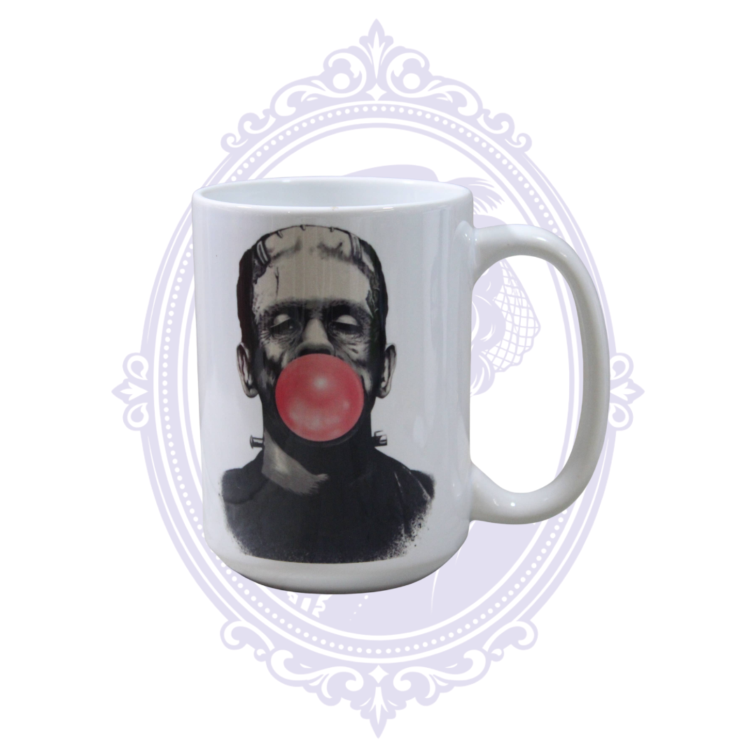 Frankenstein’s Monster blowing a pink bubblegum bubble on a white 15 oz classic horror coffee mug.