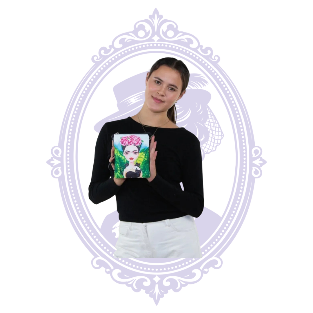 Model holding Frida-inspired crossbody purse featuring pink roses and black cats