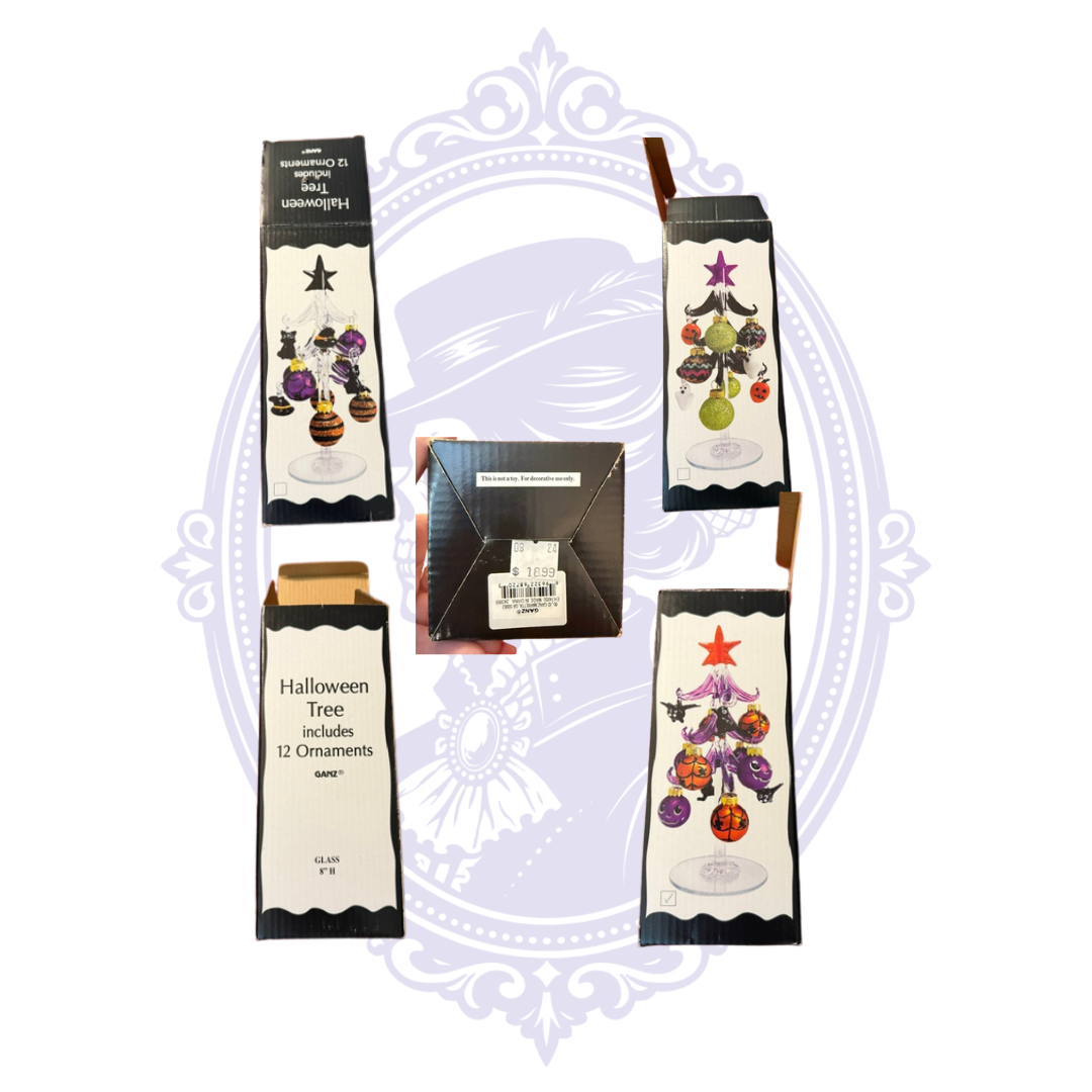 Halloween tree ornament set shown with multiple views of the retail box and one open box revealing the contents, arranged on a white background with a faint decorative purple emblem behind them.