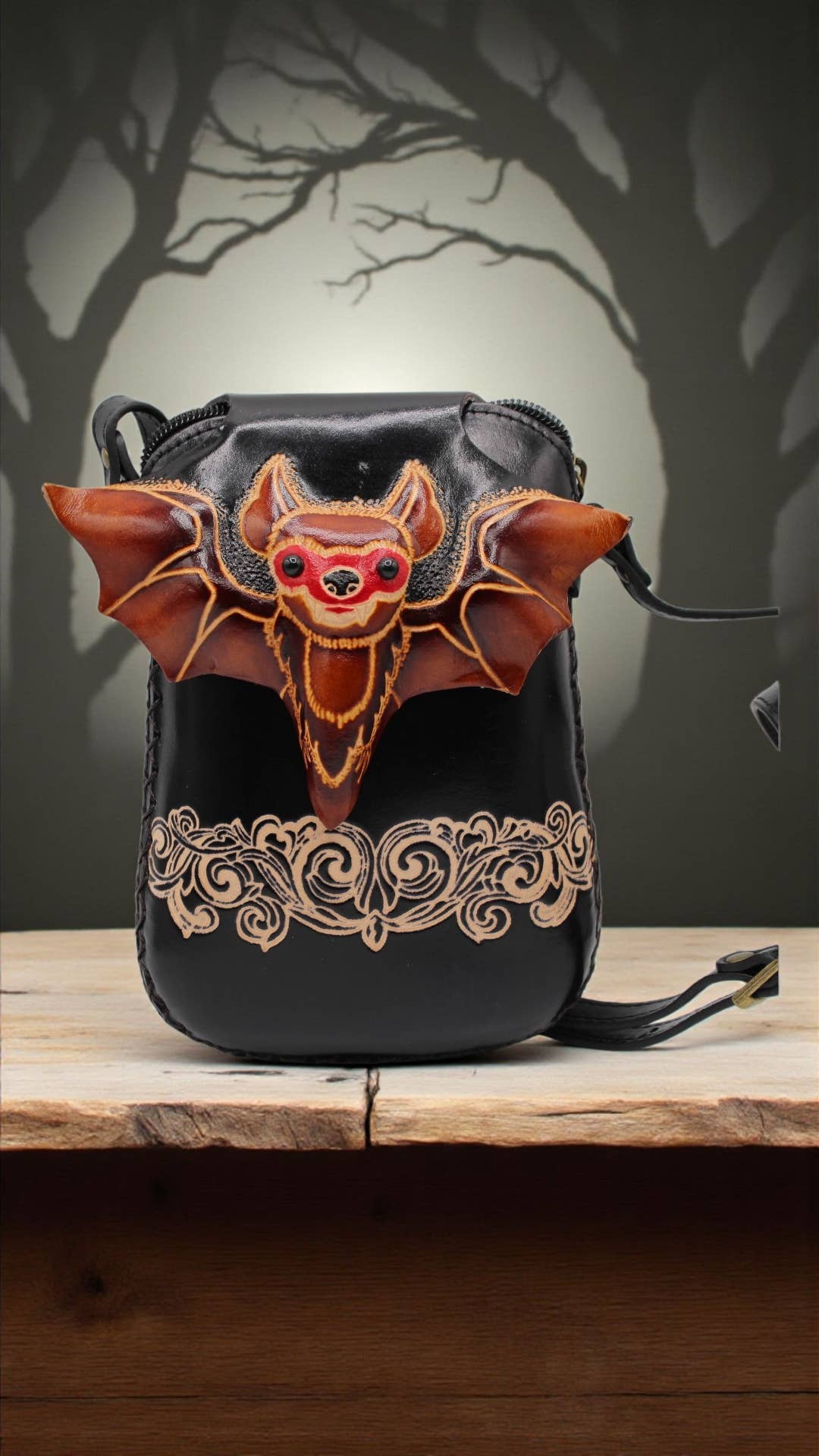 Genuine leather bat crossbody phone pouch displayed against a dark woodland background