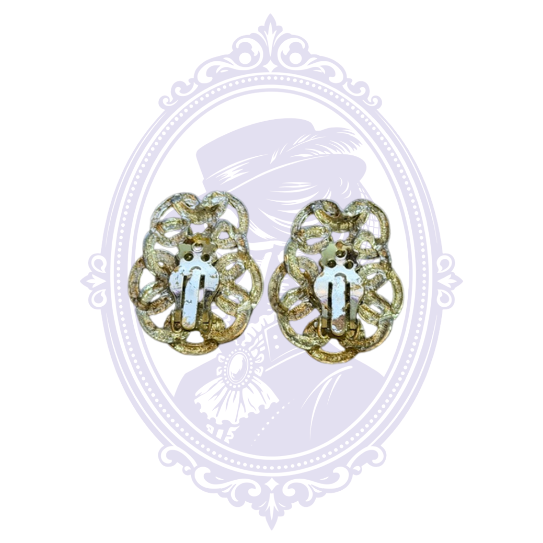 Back view of gold-tone filigree clip-on earrings showing the hinged clip mechanisms for non-pierced ears.