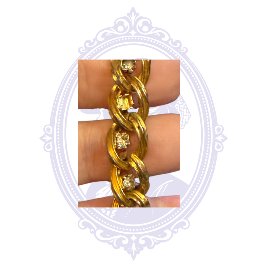 Close-up showing empty rhinestone settings and missing stones on the gold-tone bracelet.