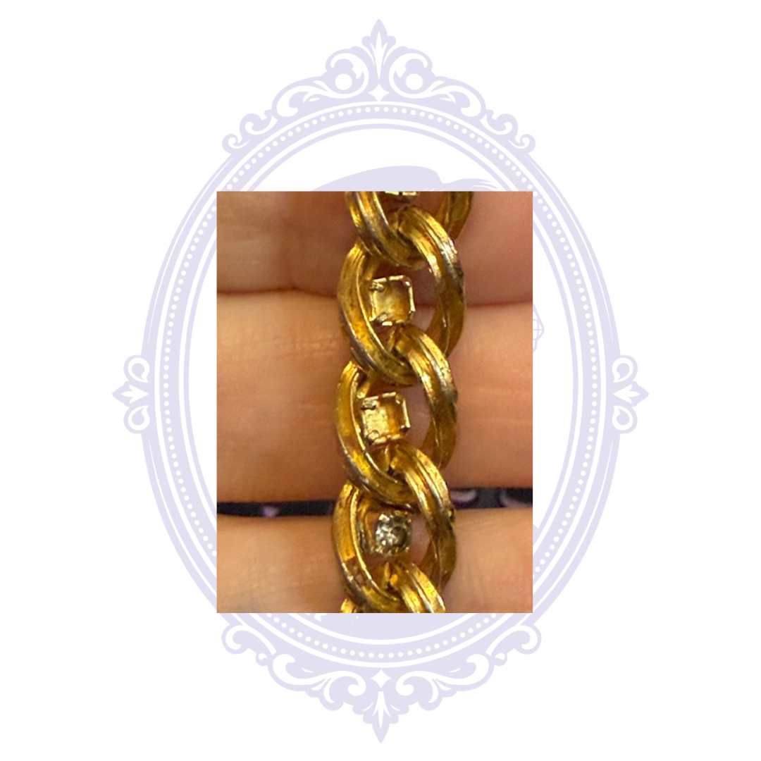 Additional condition close-up showing missing rhinestones and wear on the gold-tone curb chain bracelet.