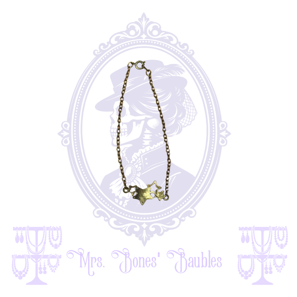 Gold-tone chain bracelet with mixed solid and open stars and spring-ring clasp