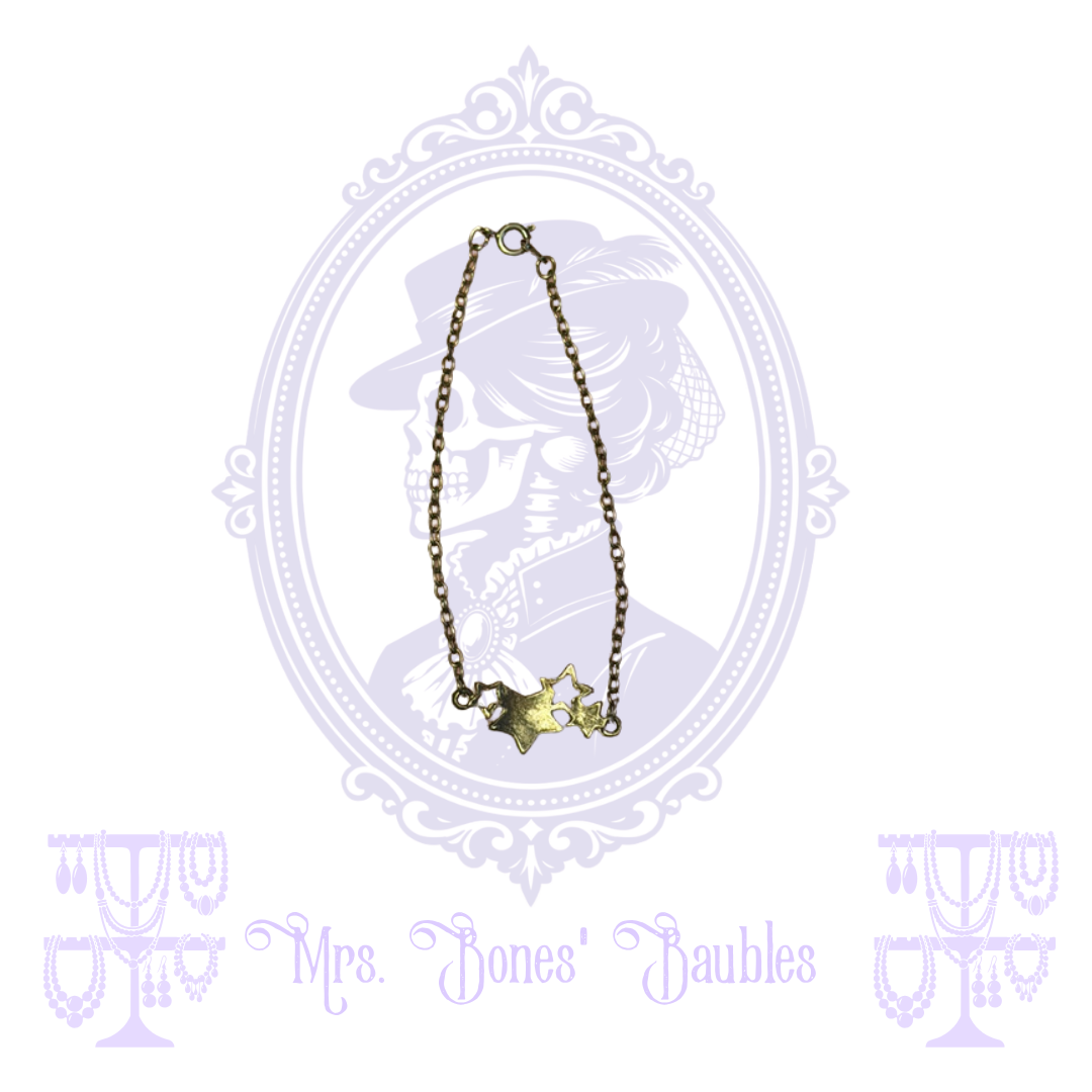 Gold-tone chain bracelet with mixed solid and open stars and spring-ring clasp