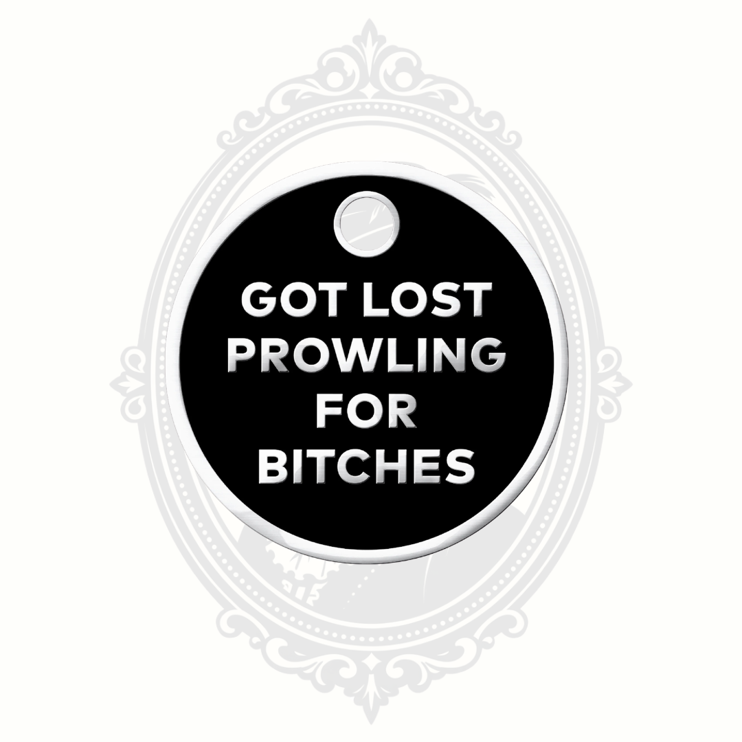 Black novelty pet tag with silver lettering reading “Got Lost Prowling for Bitches.”