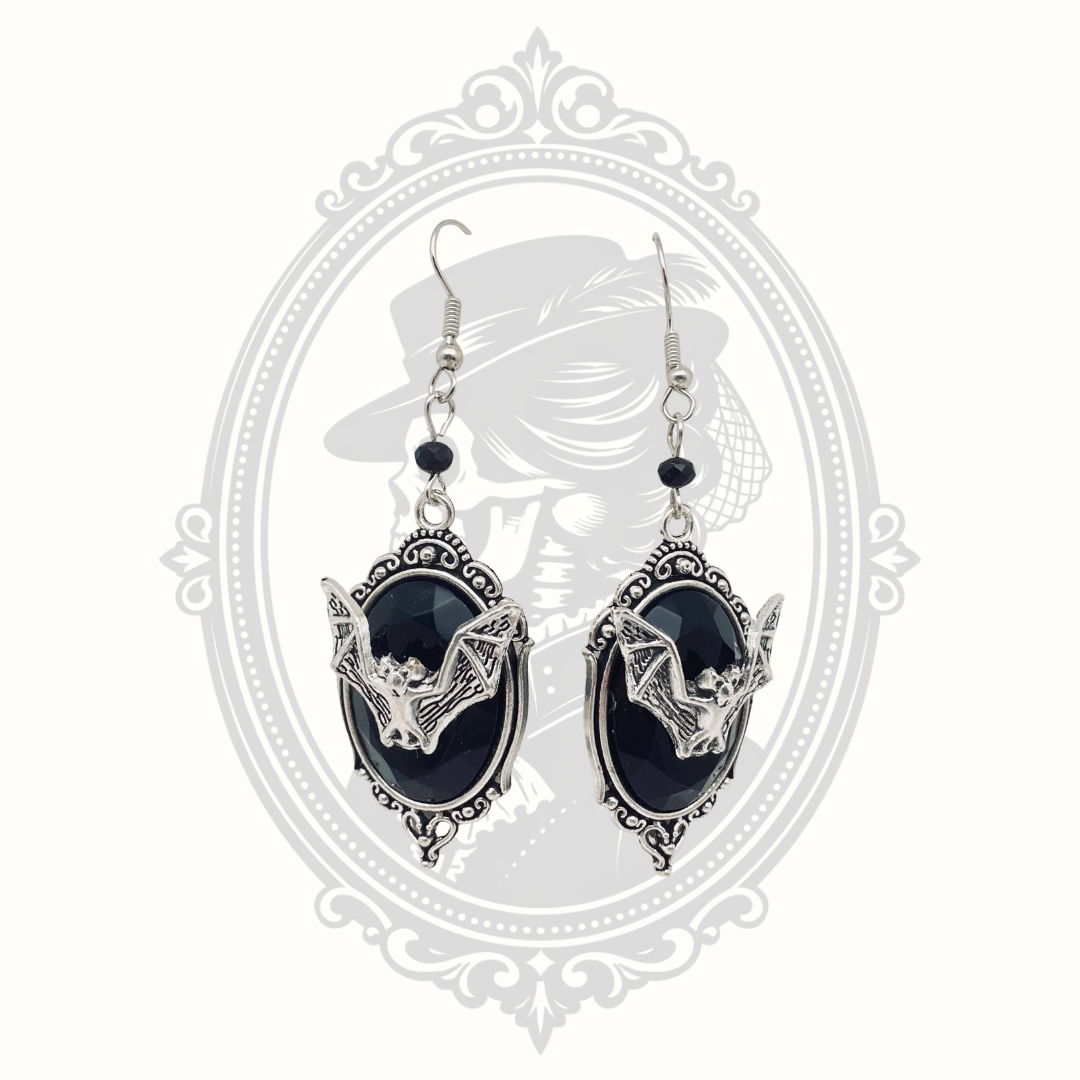 Black faceted gemstone Gothic bat drop earrings with ornate silver-tone frames.