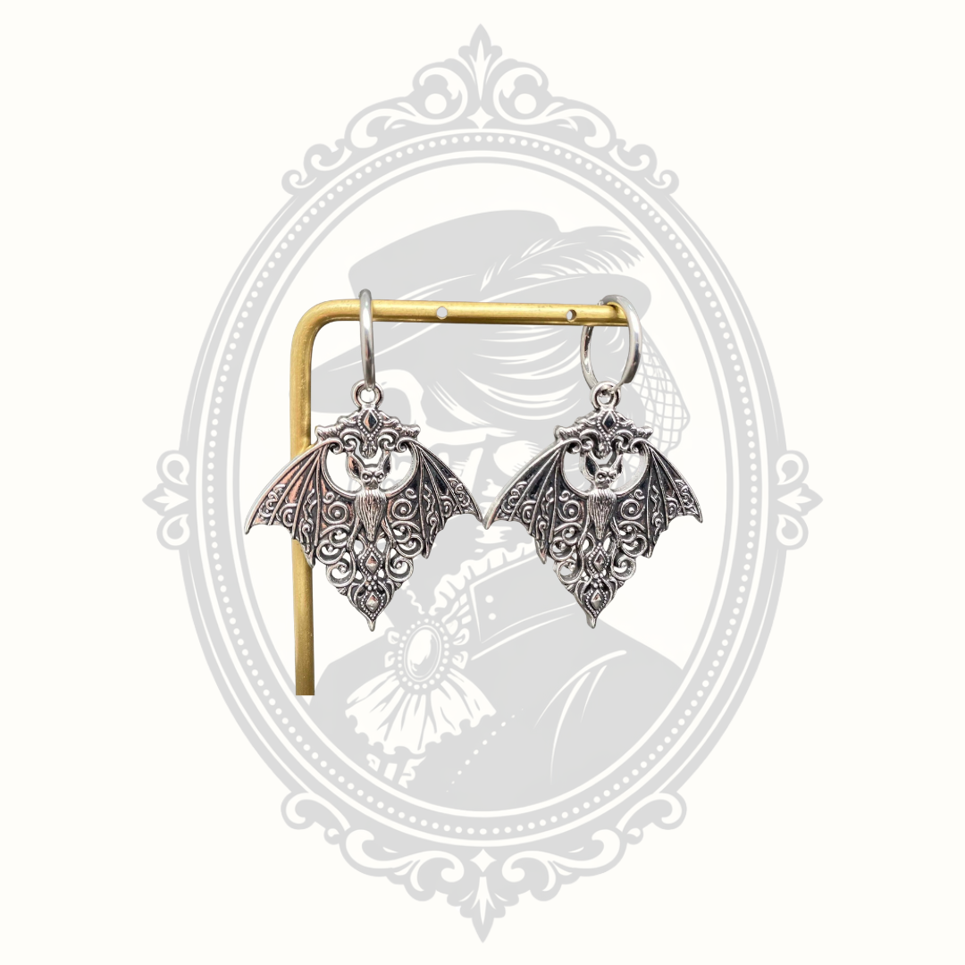 Hanging view of the Gothic bat huggie earrings highlighting their ornate detailing