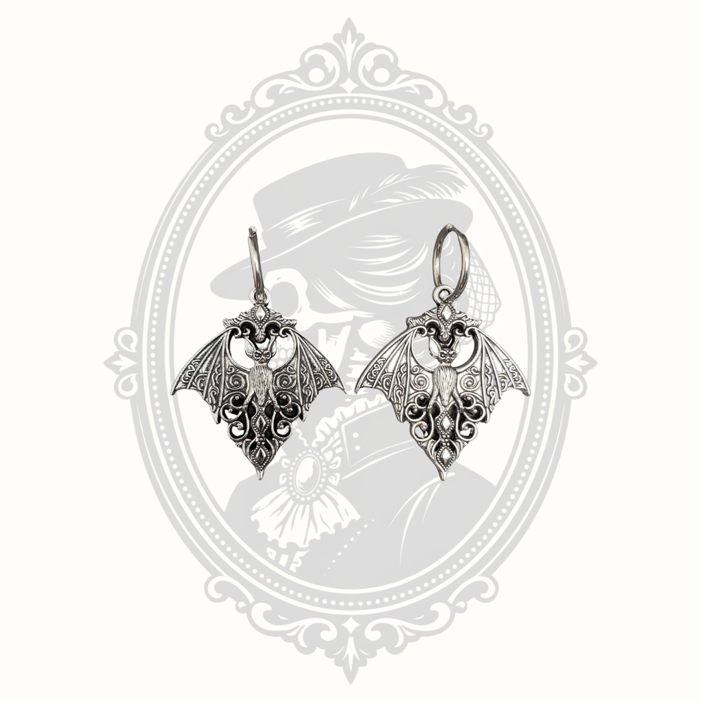 Silver-tone Gothic bat huggie earrings with intricate filigree wings.