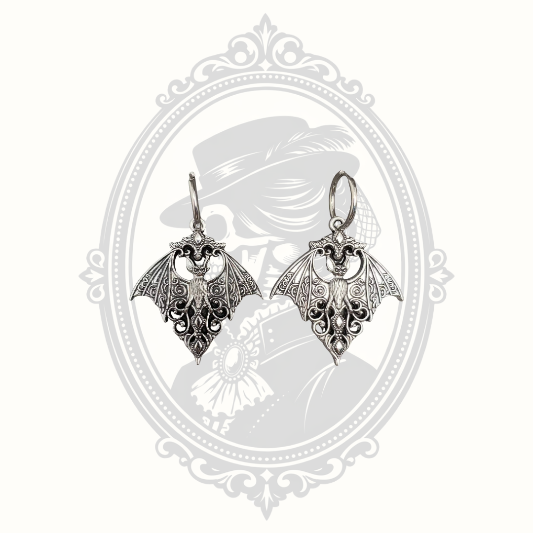 Silver-tone Gothic bat huggie earrings with intricate filigree wings.