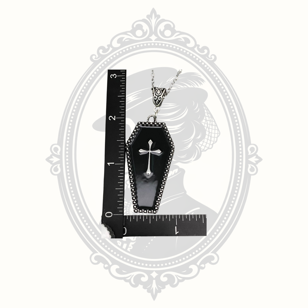 Gothic coffin cross pendant necklace shown beside ruler for size reference.