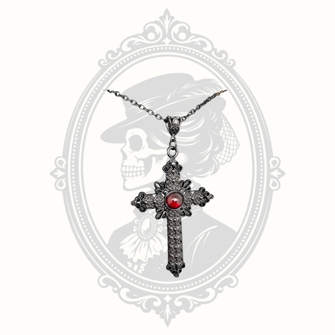 Gothic cross necklace with ornate detailing and red glass center.