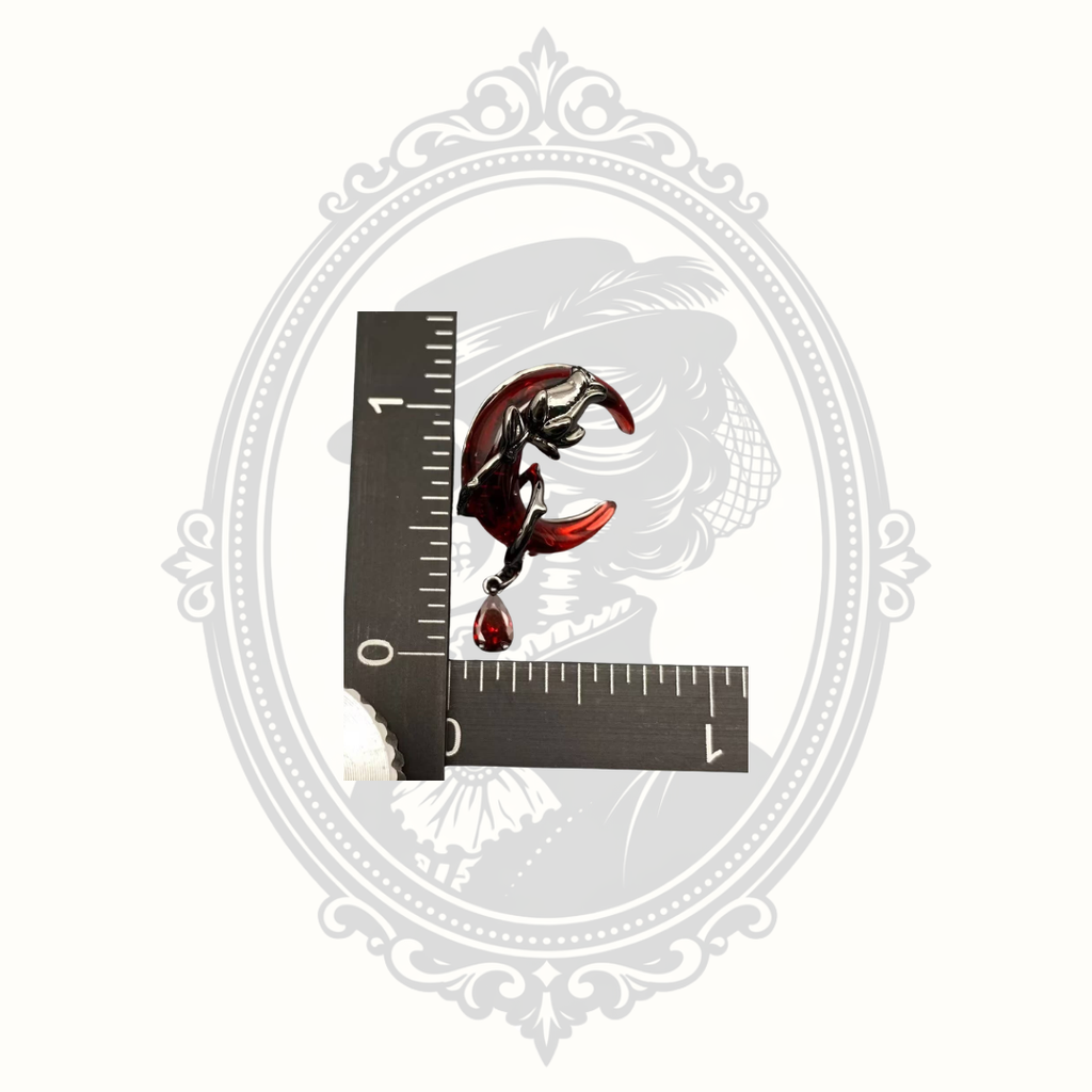 Gothic crescent moon earrings shown beside a ruler for size reference.