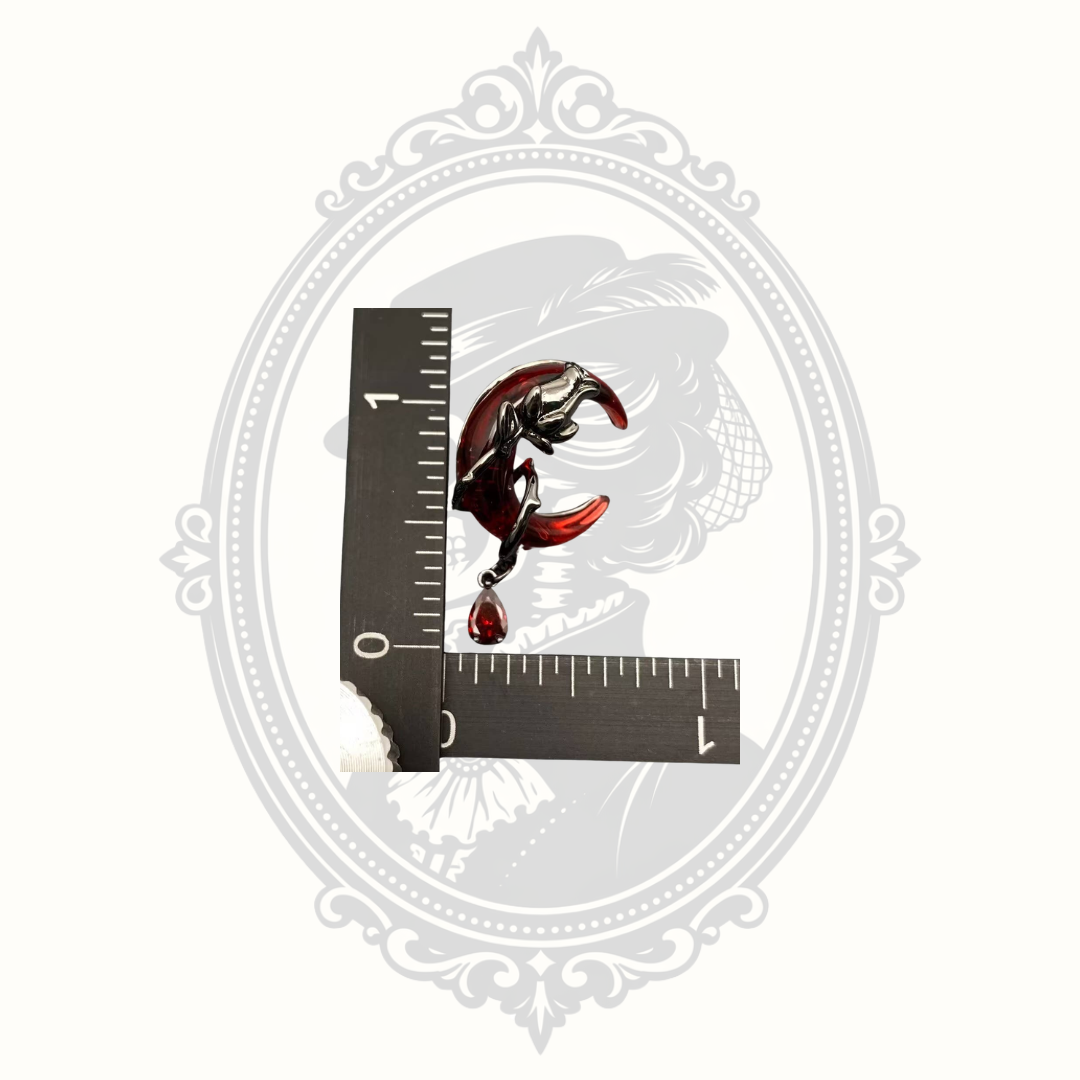 Gothic crescent moon earrings shown beside a ruler for size reference.