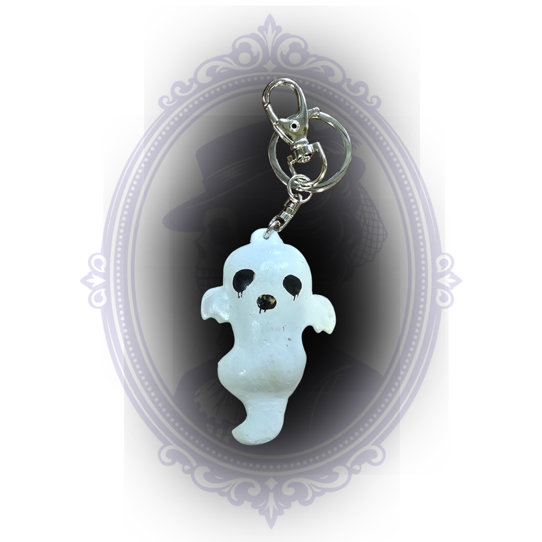 Handmade white ghost keychain showing natural variations in shape and painted details with silver-tone keyring hardware.