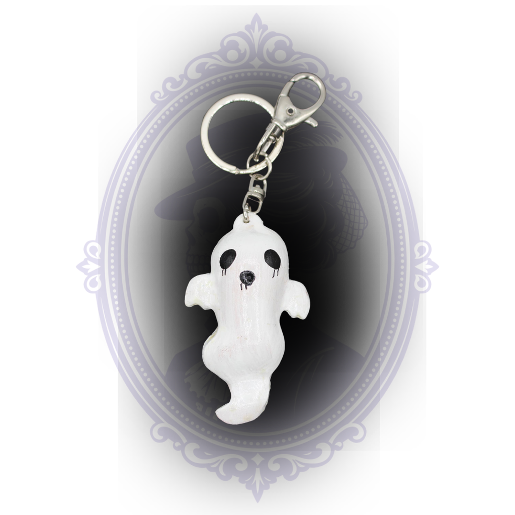 White handmade ghost keychain with curved ghost shape, black painted face, and silver-tone clip and keyring.