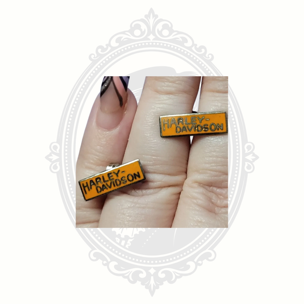 Harley Davidson orange bar earrings shown on hand for size reference
