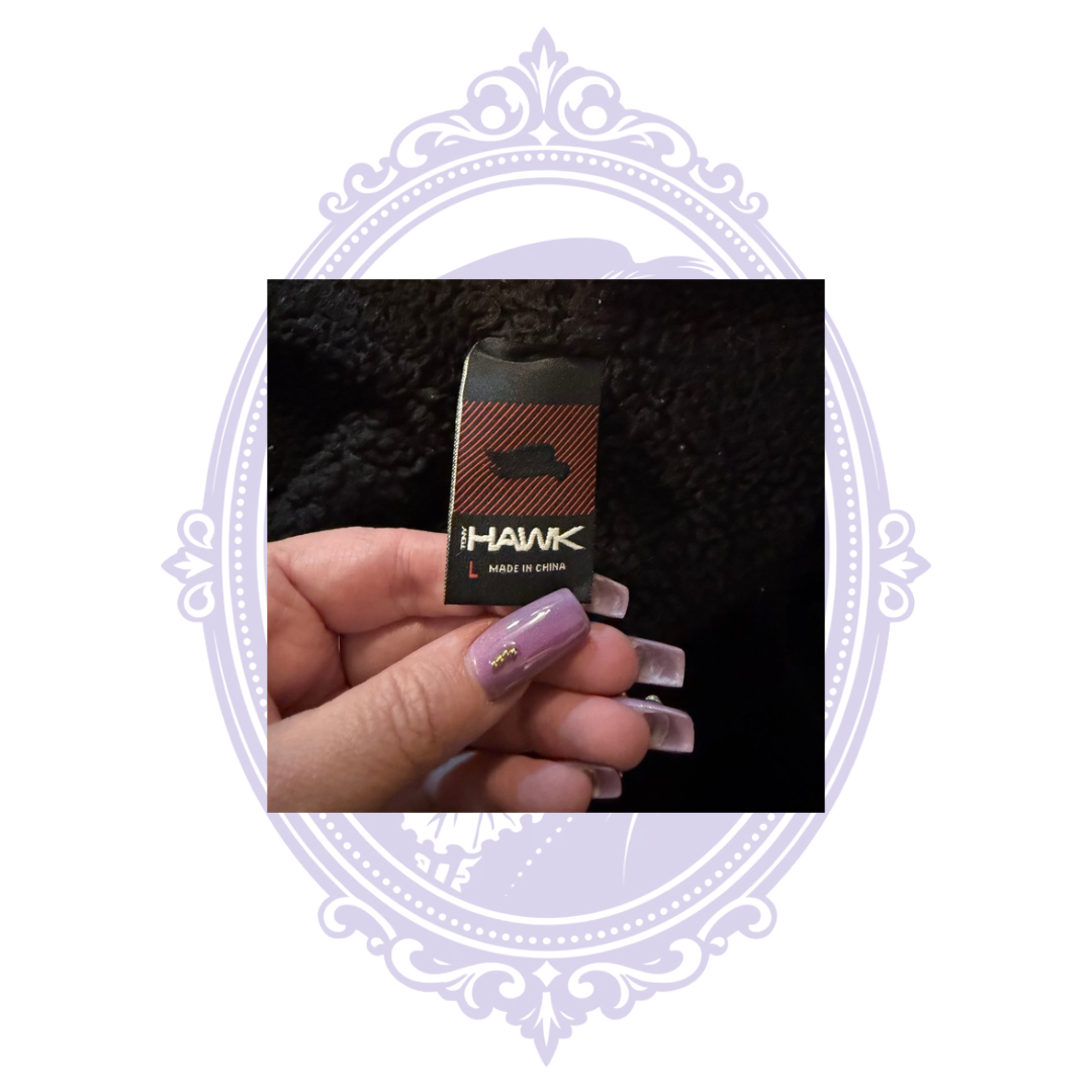Close-up of HAWK by Tony Hawk clothing label showing tagged size Large and Made in China on boys gray and black hooded jacket.