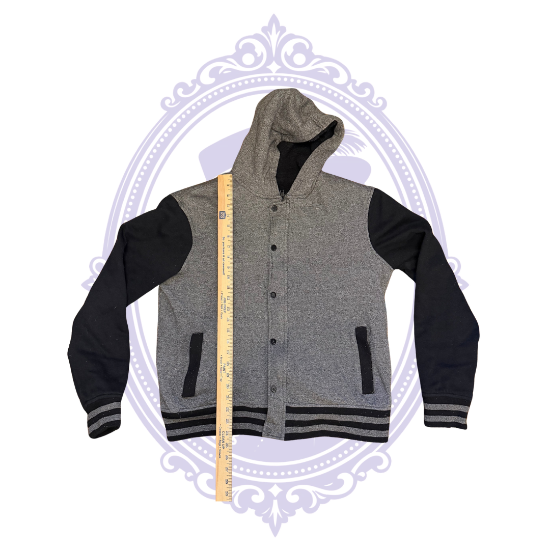 Measurement photo of HAWK boys Large gray and black hooded varsity jacket with ruler across chest to show approximate flat pit-to-pit width.