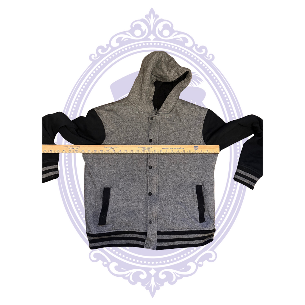 Measurement photo of HAWK boys Large gray and black hooded jacket with ruler held vertically along front to show approximate jacket length.