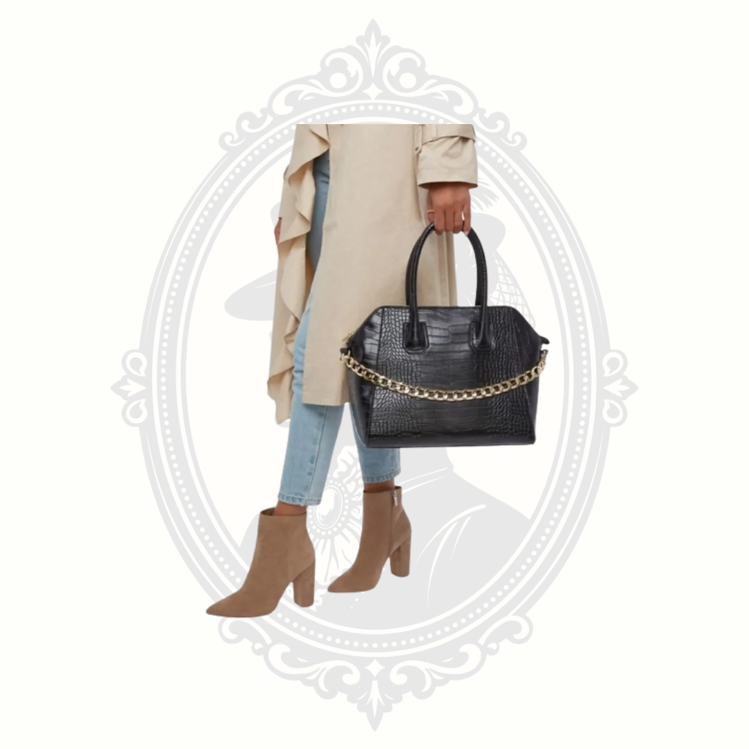 Woman holding JustFab black croc embossed satchel bag with gold chain detail