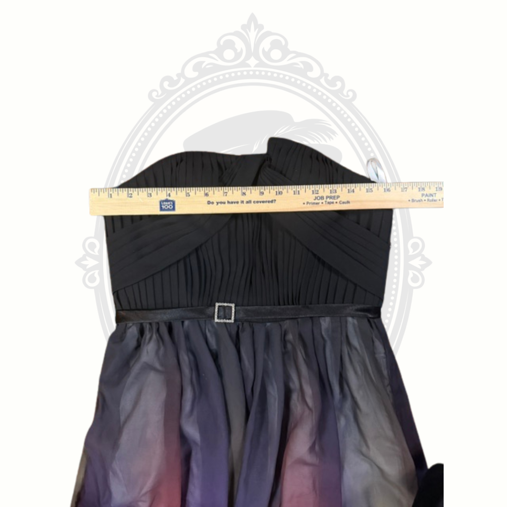 Black dress with a gradient skirt and a ruler for size reference on a white background