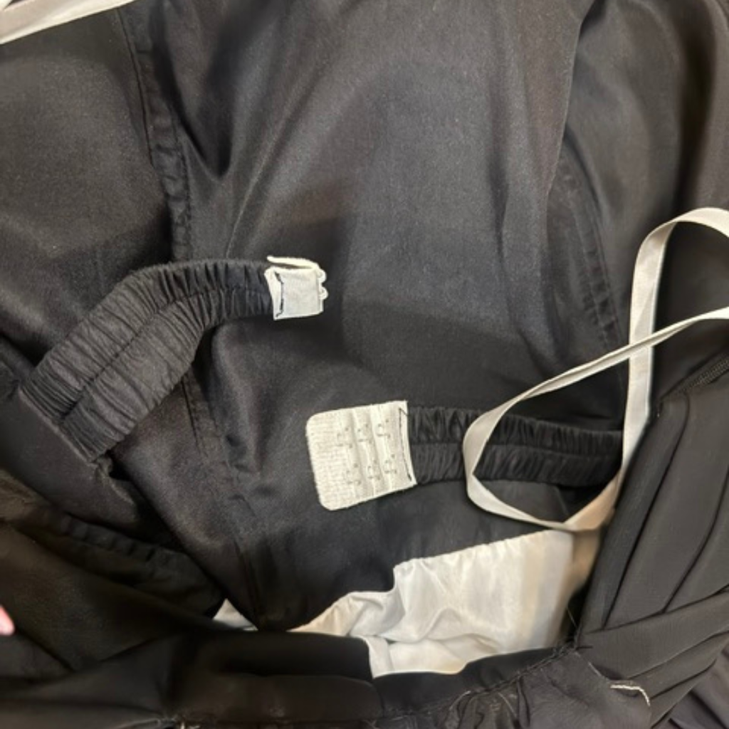 Close-up of a black jacket with visible labels on a dark background
