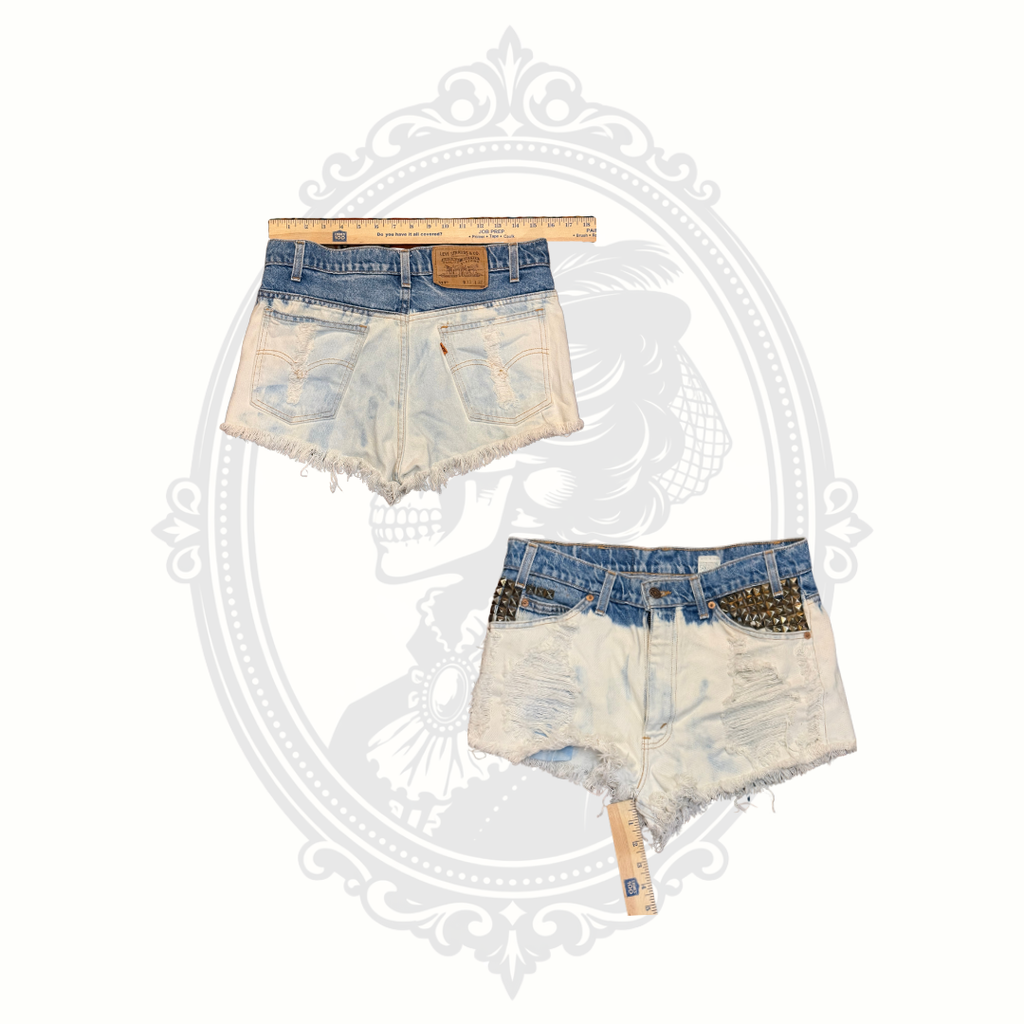 Front and back measurement view of vintage Levi’s 517 studded denim shorts with distressed detailing and cutoff styling.