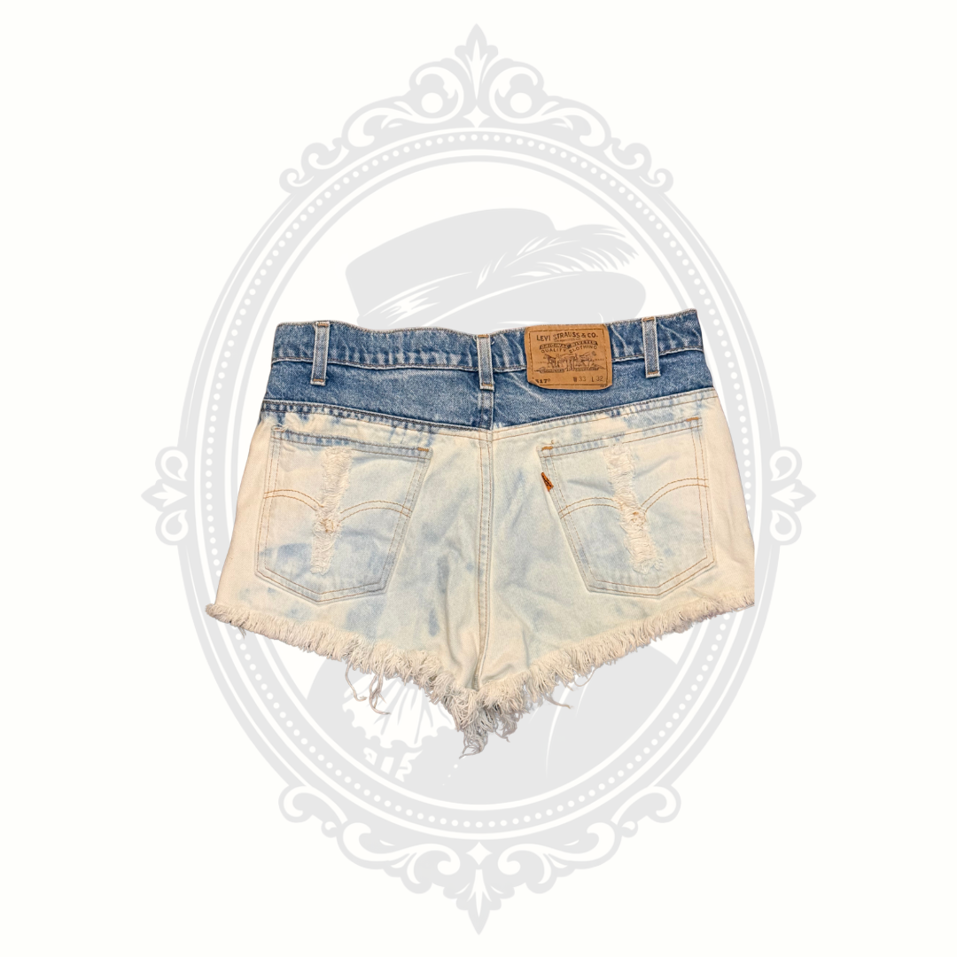 Back view of Levi’s 517 distressed denim cutoff shorts with frayed hem and faded wash