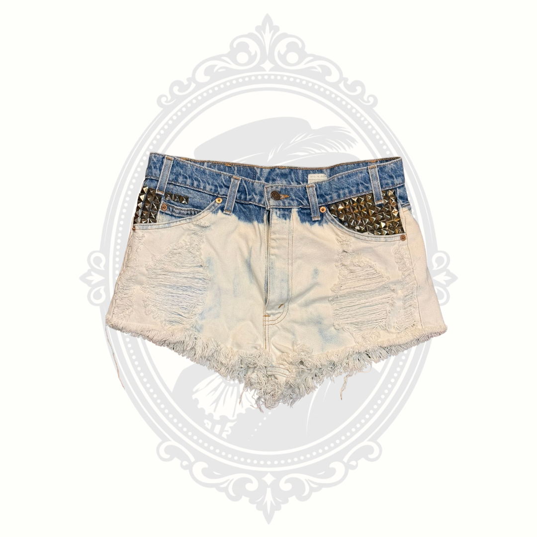 Front view of Levi’s 517 studded distressed denim cutoff shorts with frayed hem