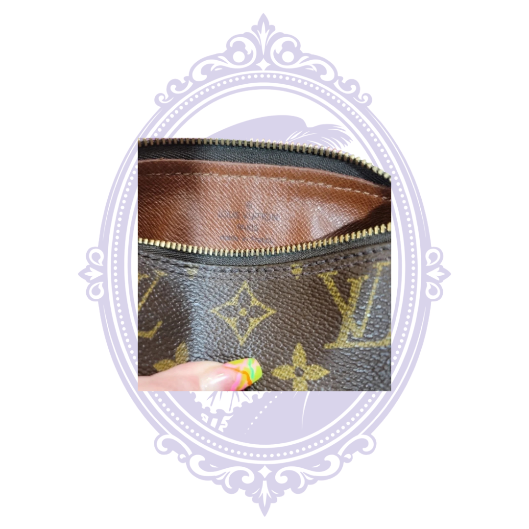 Interior Louis Vuitton stamp and brown lining beneath zipper