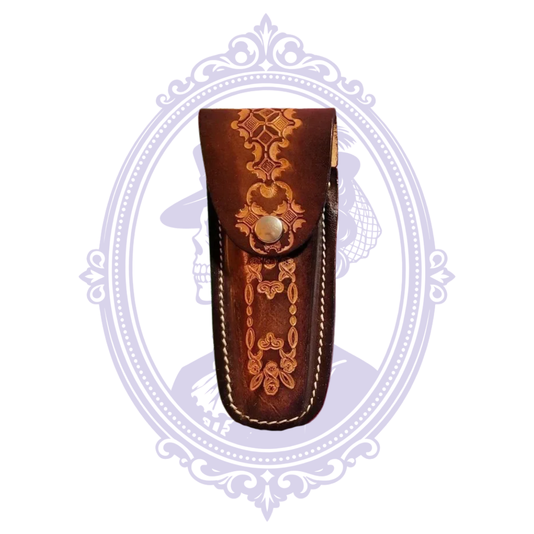 Front view of vintage brown tooled leather knife sheath with ornate geometric floral snap flap and contrasting stitching