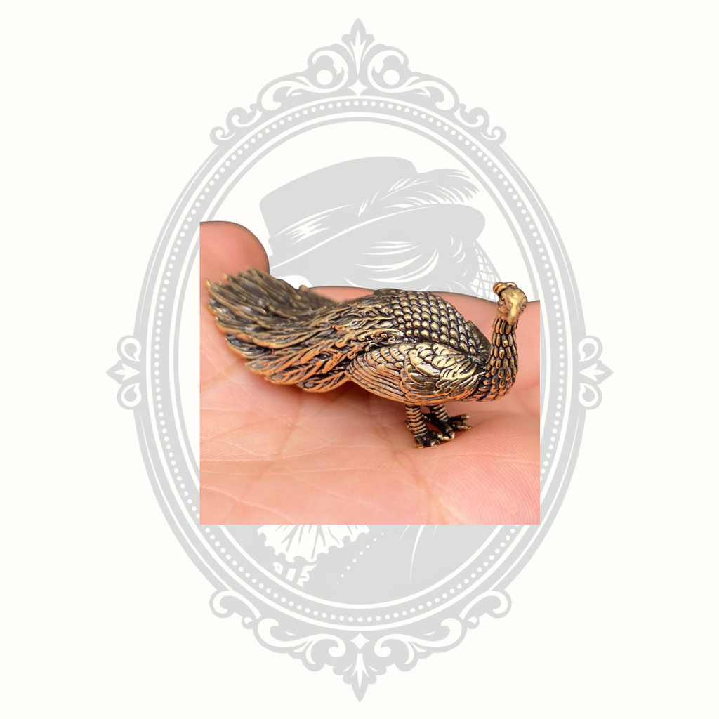 Solid brass peacock ornament displayed in the palm of a hand for scale.