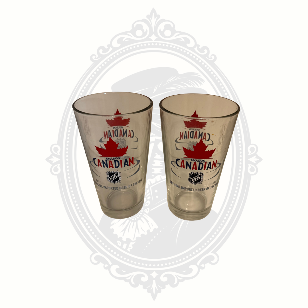 Set of two Molson Canadian NHL beer pint glasses with maple leaf logo and hockey branding.
