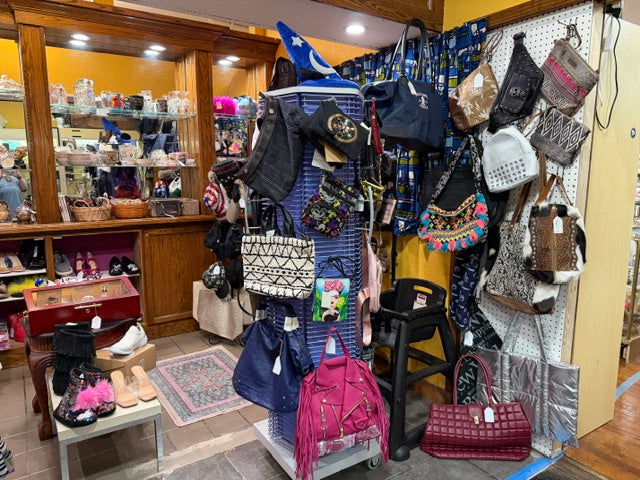 Handbags and accessories displayed inside Mrs. Bones Curio Cupboard at The Rusty Crown, Booth 571 in Pittsburgh, Pennsylvania.