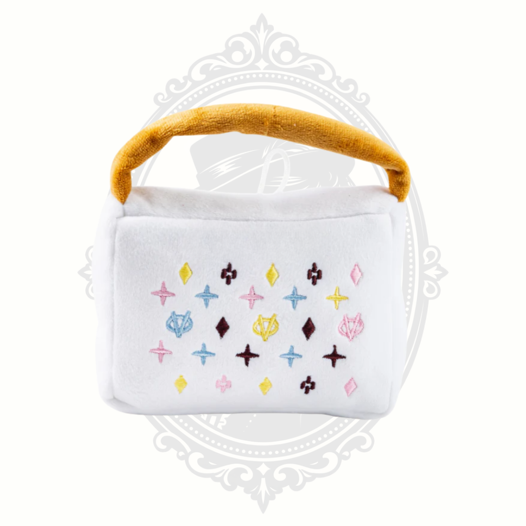 White plush dog toy handbag with colorful embroidered pattern and soft handle for interactive play