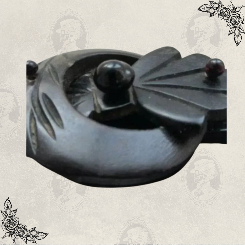 Close-up detail of Victorian Odd Fellows mourning brooch clasp, showing carved gutta percha buckle and decorative elements
