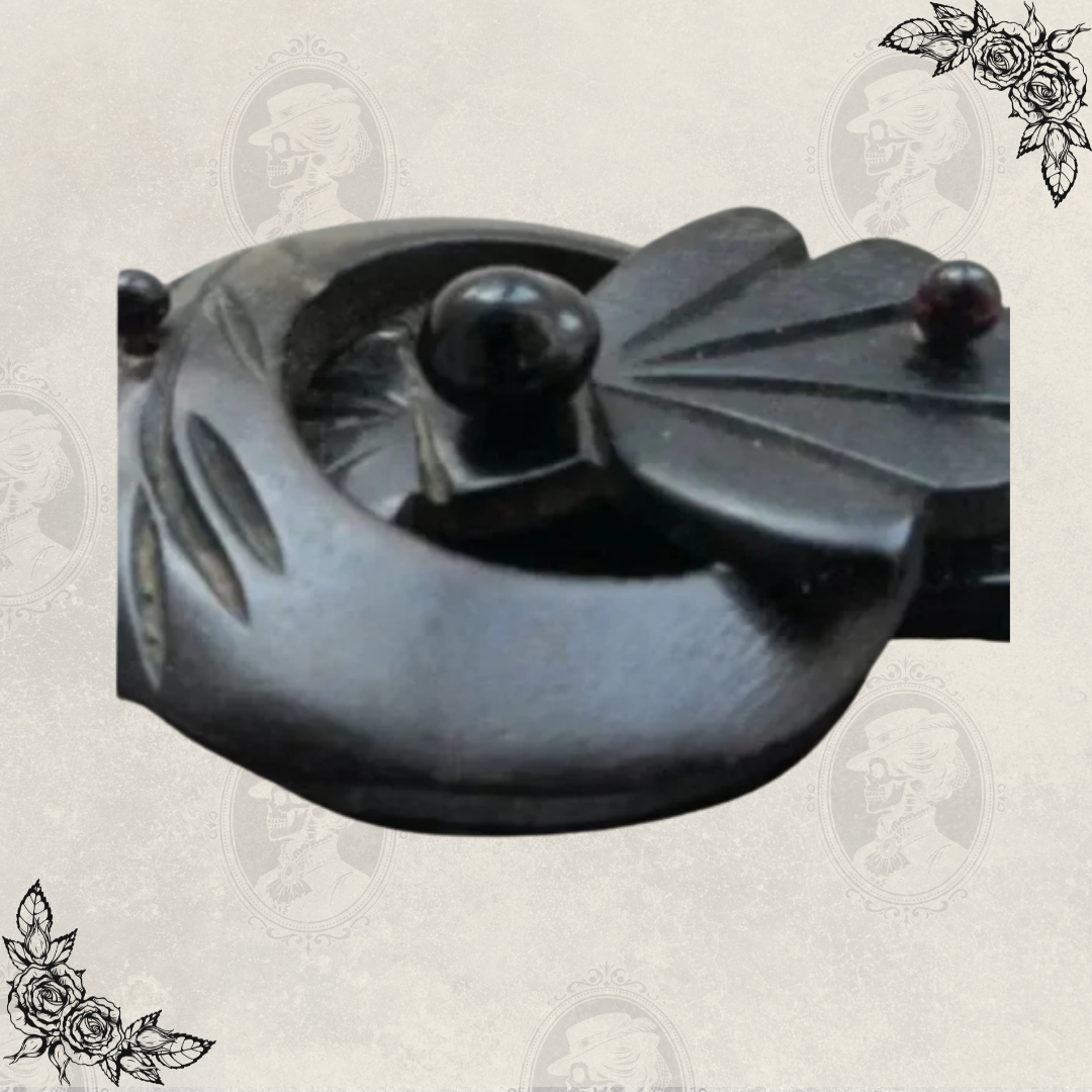 Close-up detail of Victorian Odd Fellows mourning brooch clasp, showing carved gutta percha buckle and decorative elements