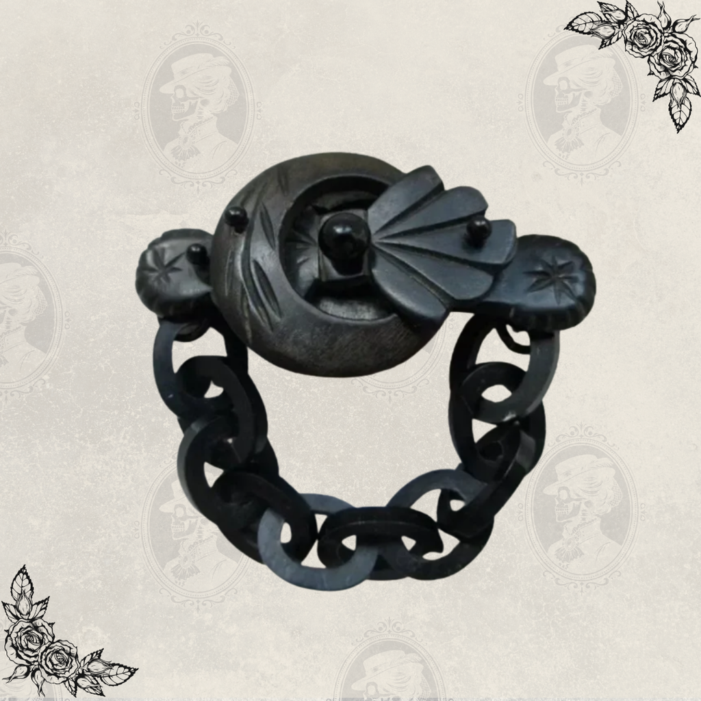 Front view of antique Victorian mourning brooch with chain drop, made of carved gutta percha, associated with Odd Fellows