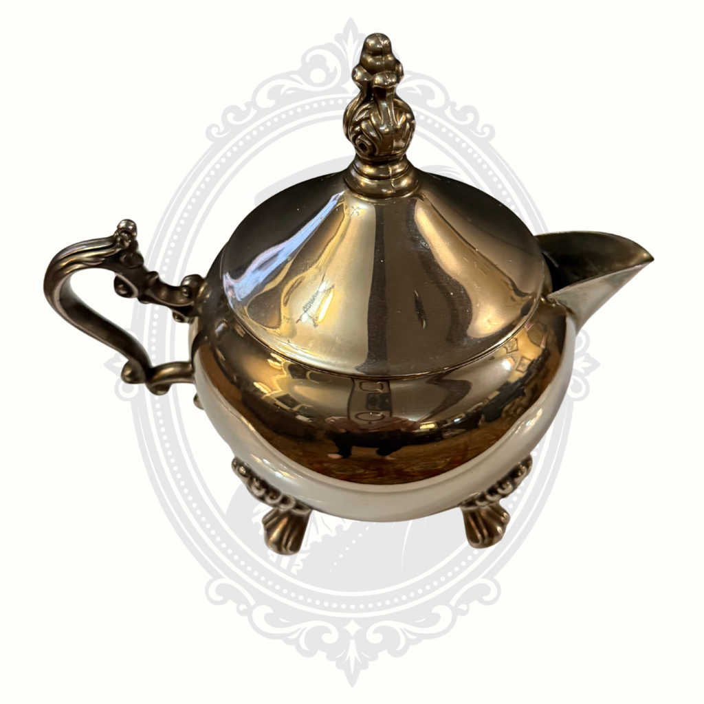 Silver-plated teapot with decorative elements on a white background