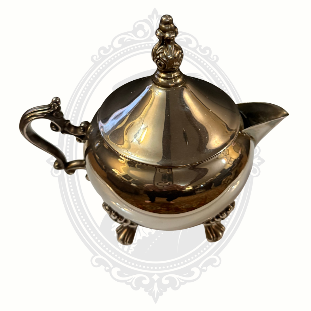 Silver-plated teapot with decorative elements on a white background