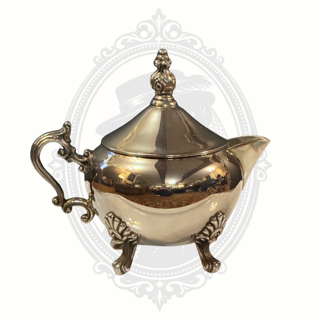 Silver-plated ornate teapot on a decorative white background