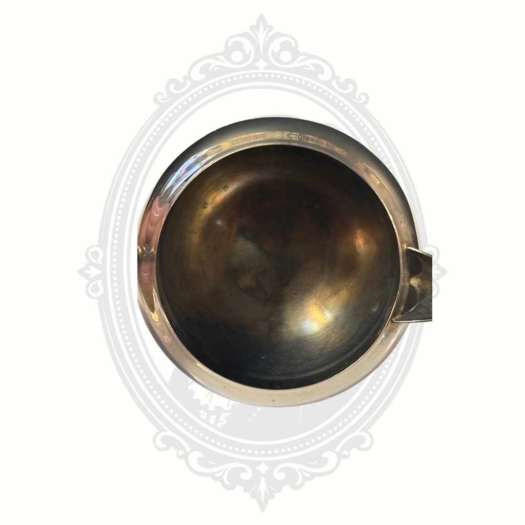 Silver-plated sugar bowl with a handle on a white background