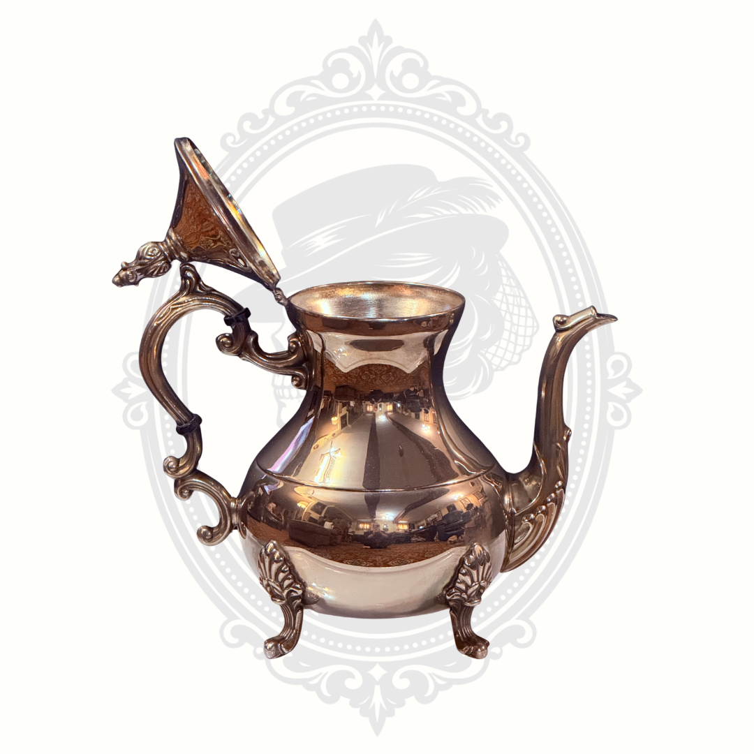 Silver-plated pitcher with decorative handles on a white background