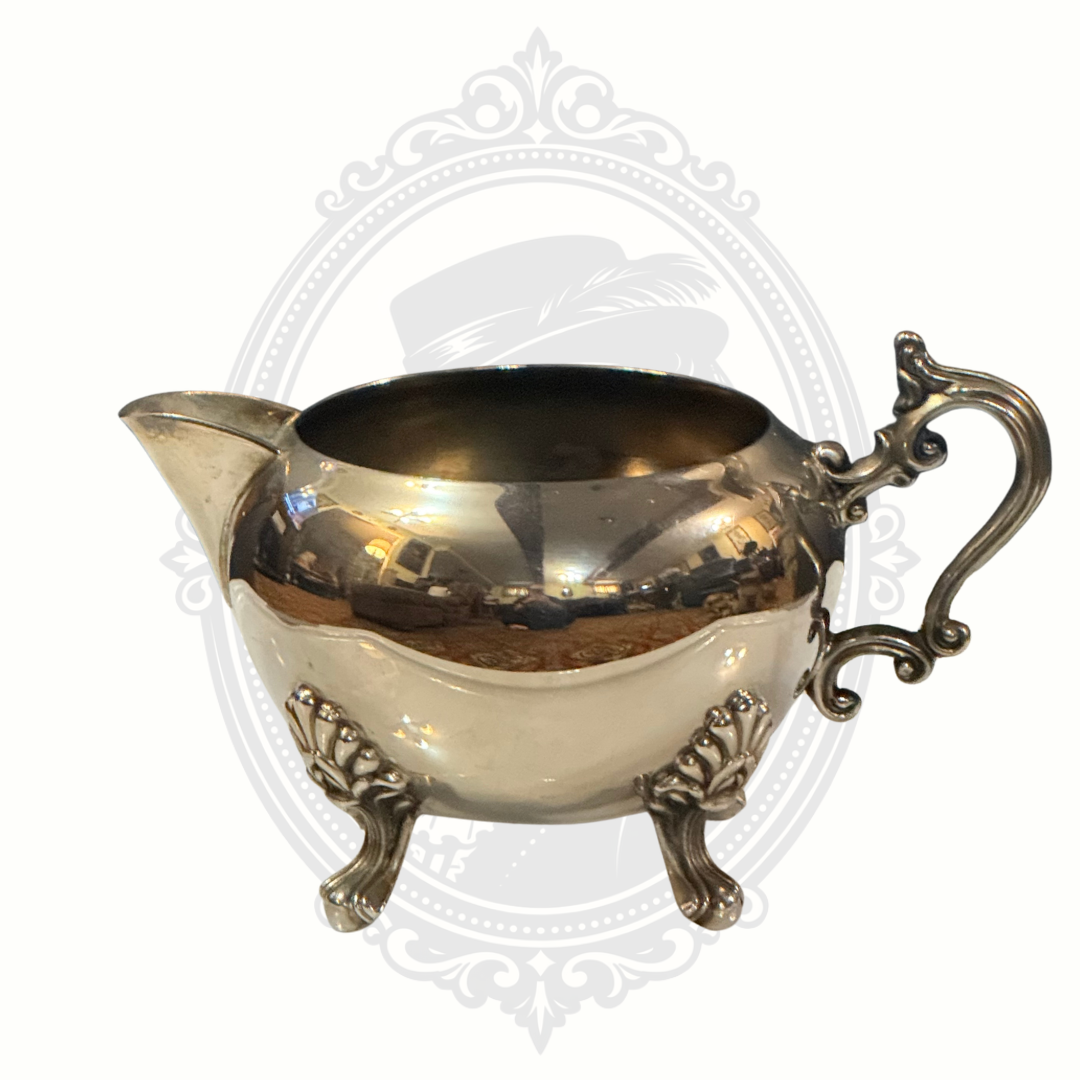 Decorative silver-plated sugar bowl with handle on a white background