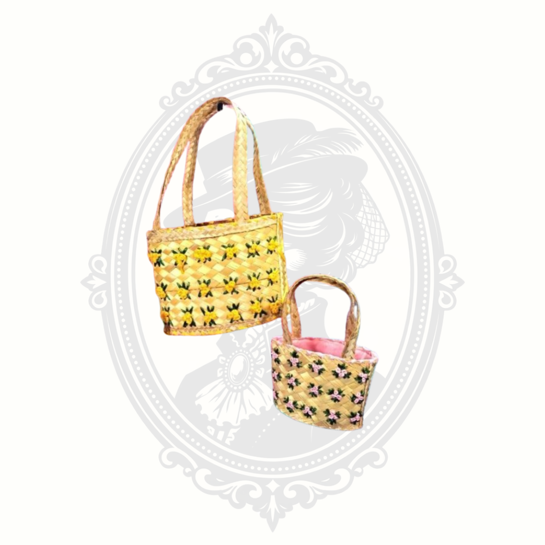 Angled view of two woven baskets with floral embroidery and braided handles, showing texture and design