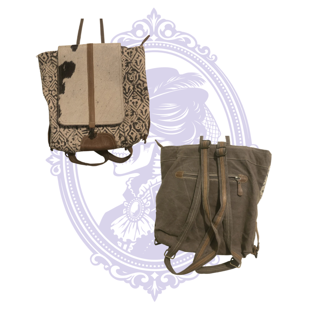 Front view of Myra Bag black and cream geometric backpack with spotted cowhide flap