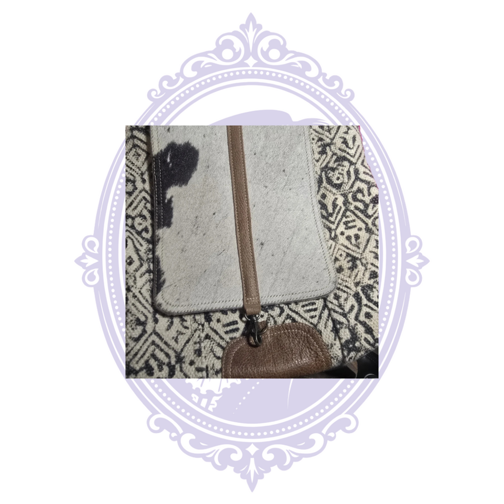 Spotted cowhide flap and brown trim detail